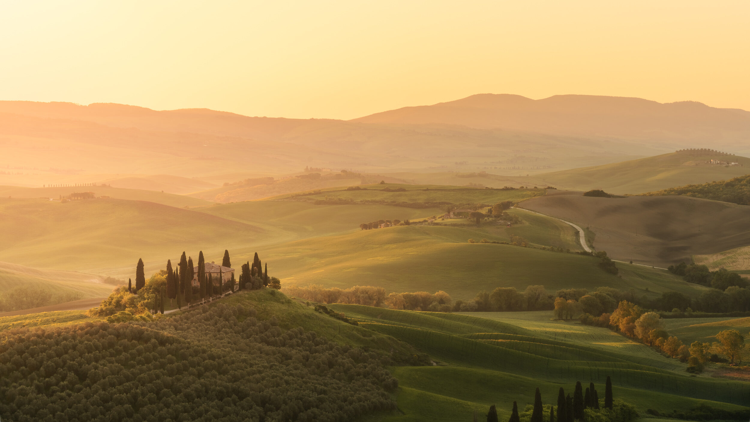 Ferme toscane entourée de cyprès au lever du soleil dans les collines