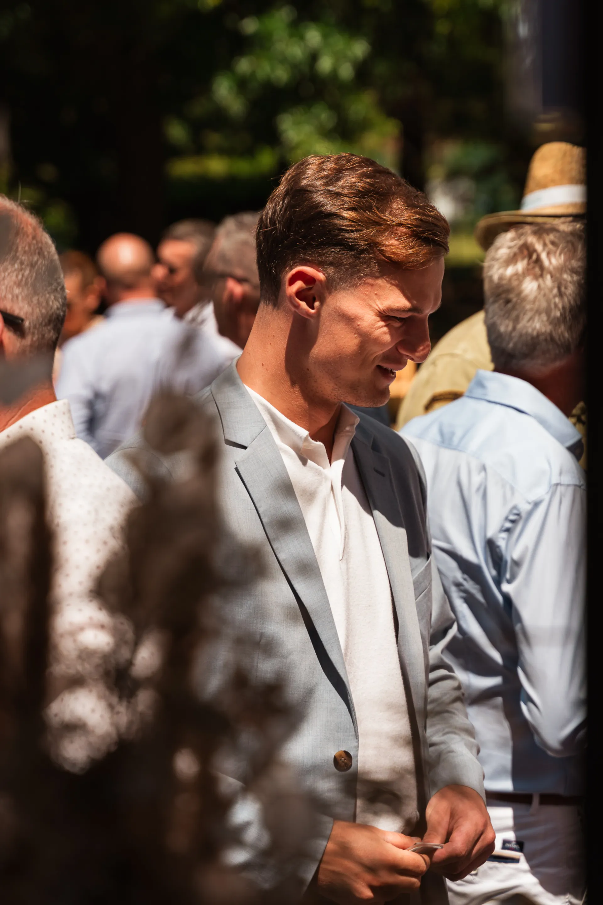 Jeune homme en costume souriant lors d'un événement