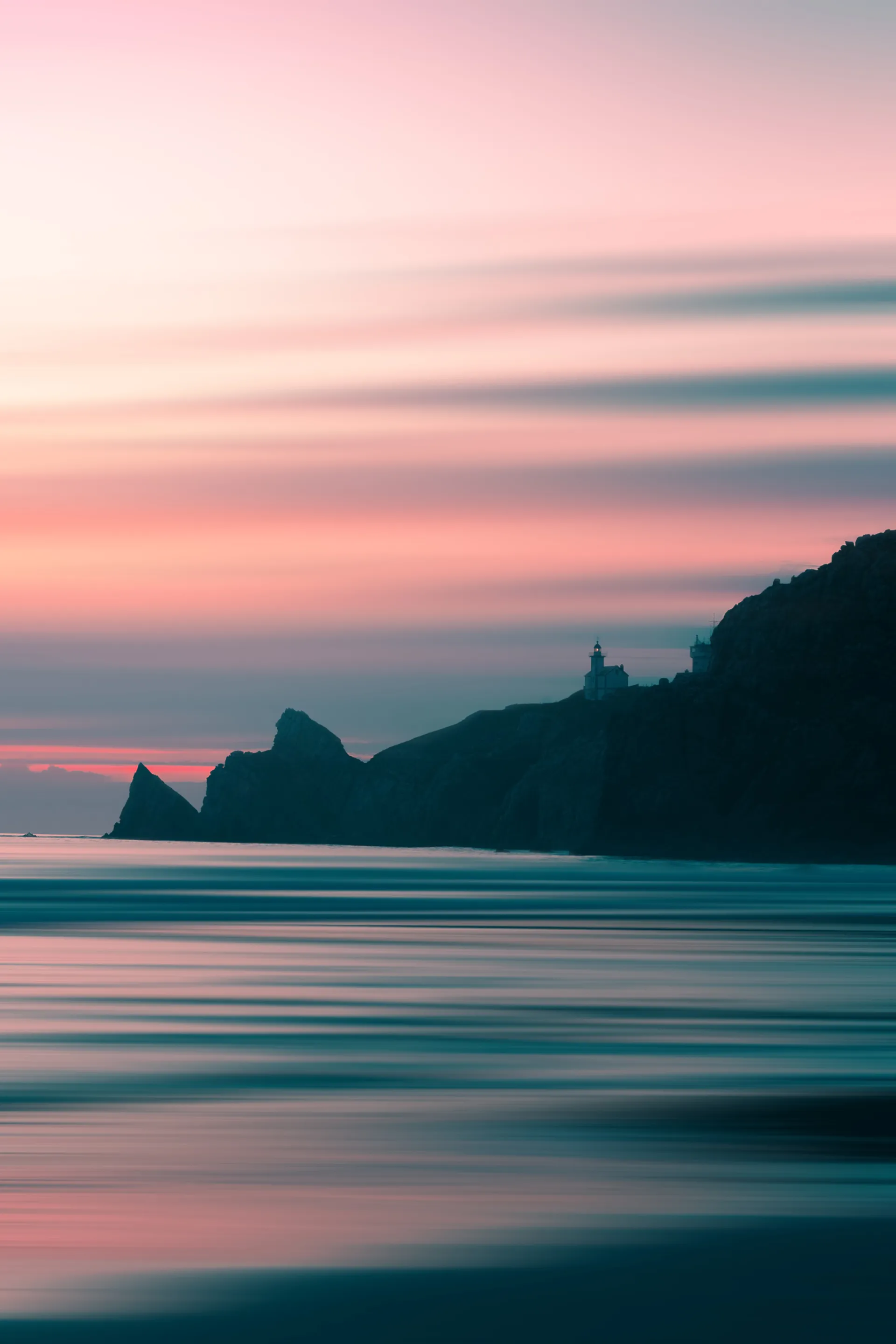 Phare sur une falaise sous un ciel rose