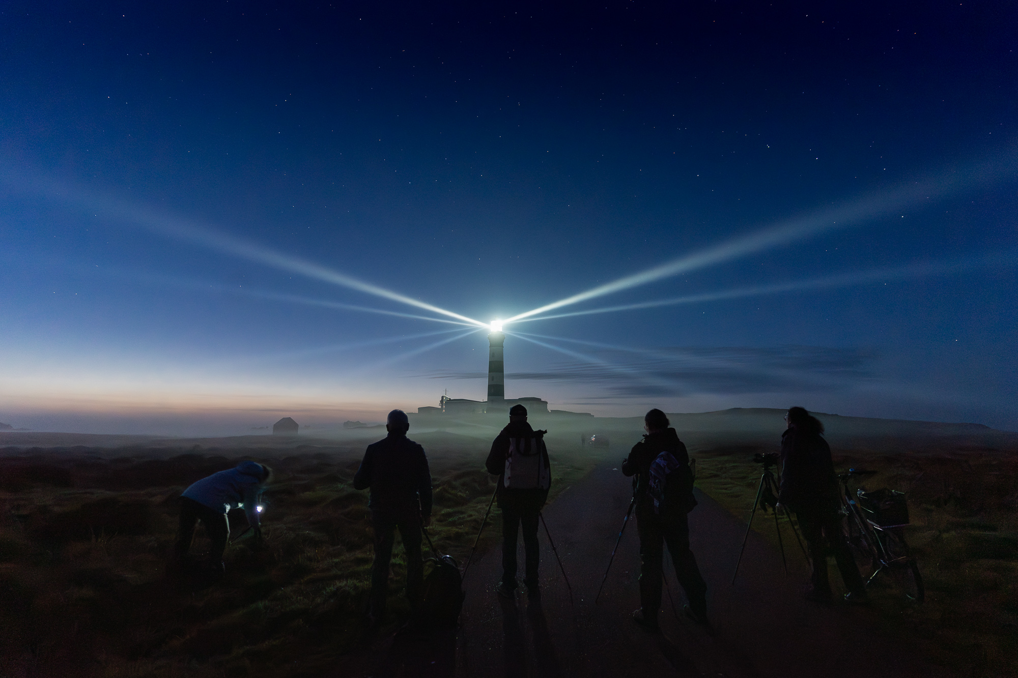 Photographes devant un phare breton dans la nuit étoilée