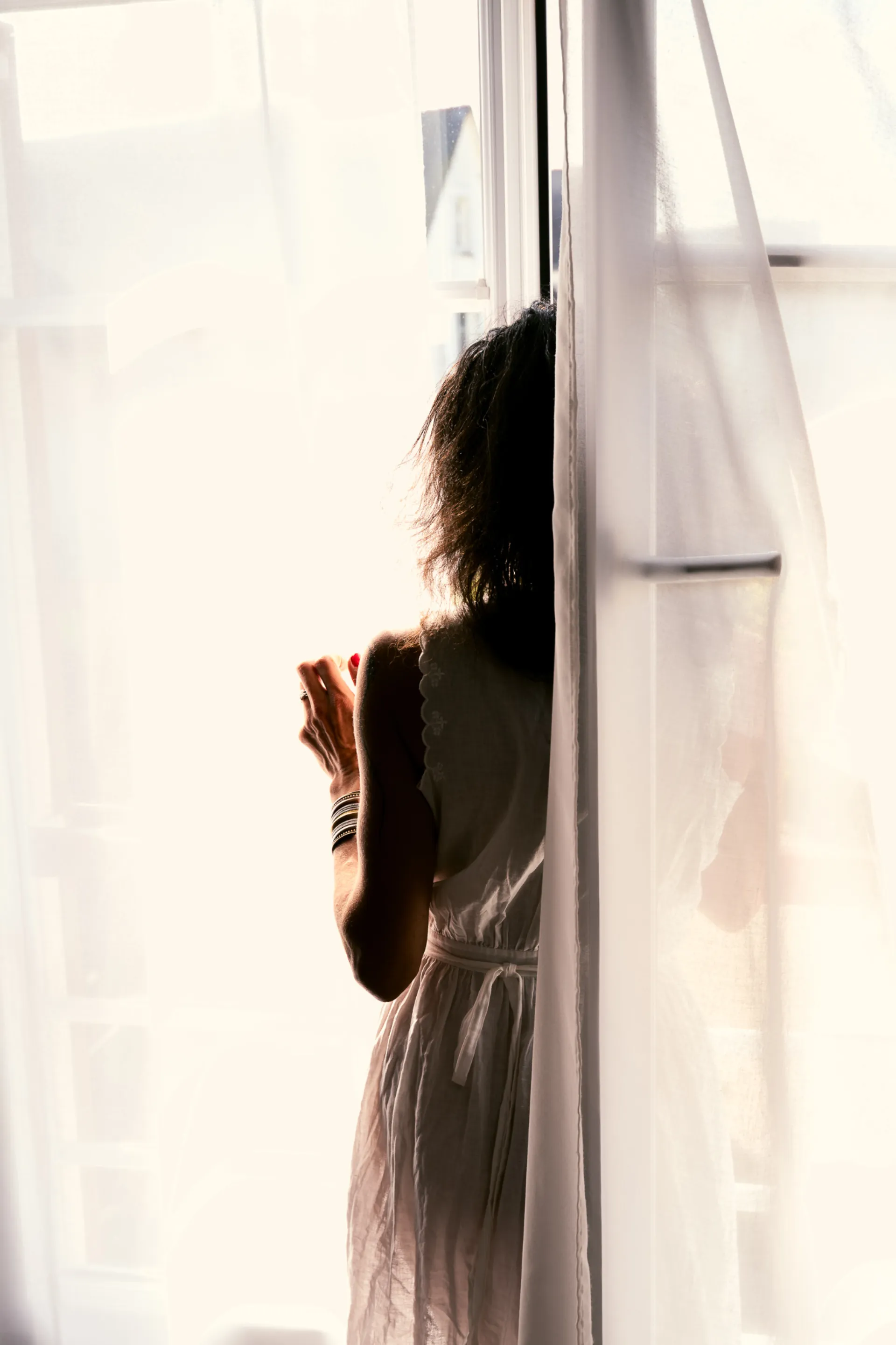 Silhouette féminine devant une fenêtre lumineuse